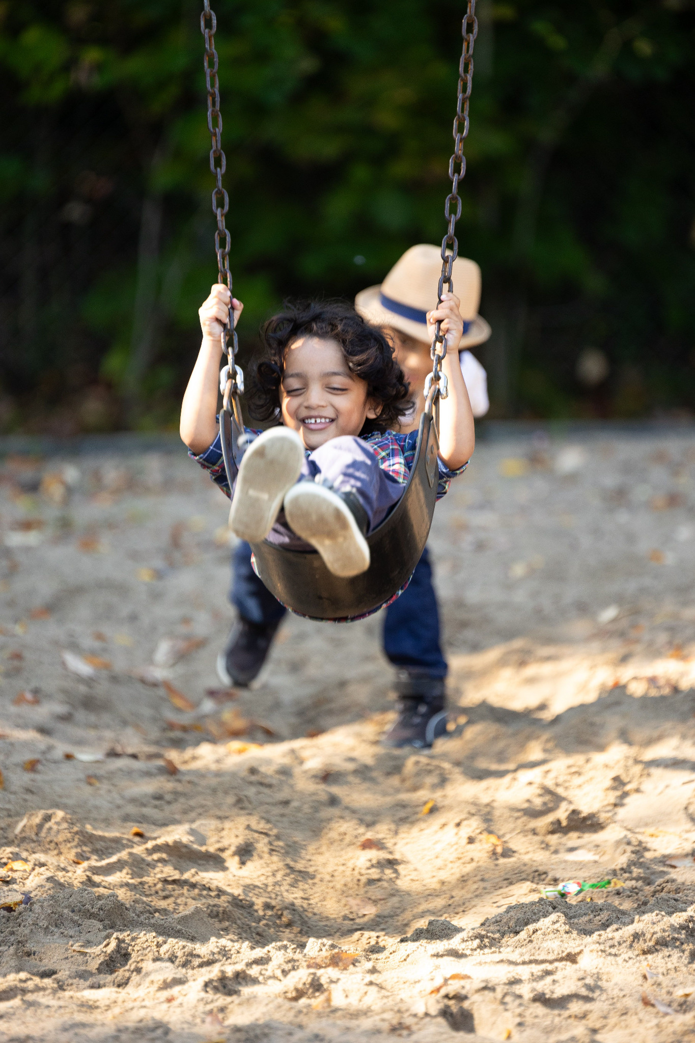 Child building confidence through movement on an outdoor swing